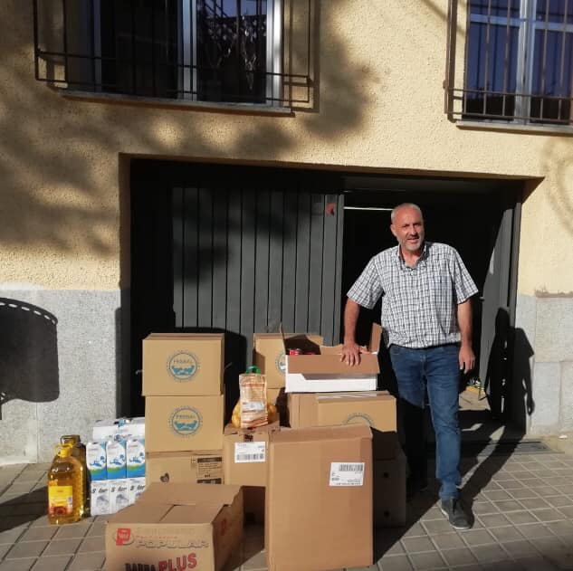 Voluntario junto a las cajas de alimentos donados en Pantoja