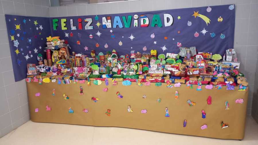 Belén hecho por los alumnos del CEIP Jacinto Guerrero con alimentos y el cartel Feliz Navidad