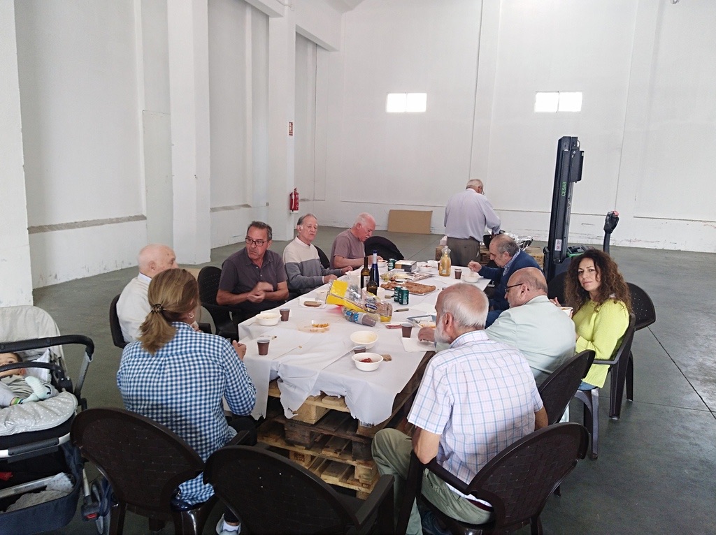 Voluntarios sentados a la mesa en el almuerzo de hermandad en el almacén