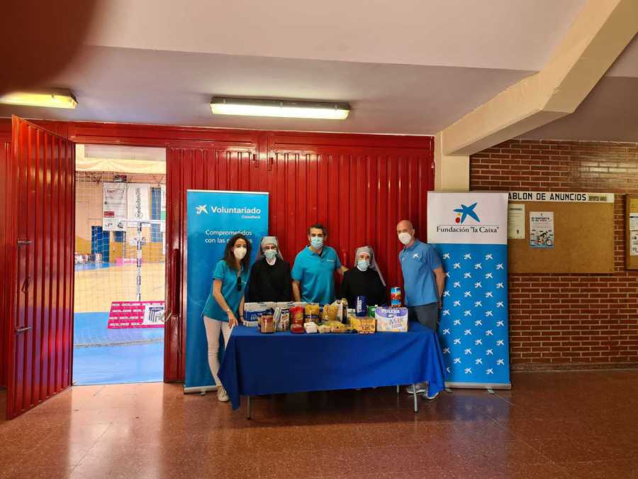 Mesa de recogida de alimentos del voluntariado de la Caixa en un polideportivo