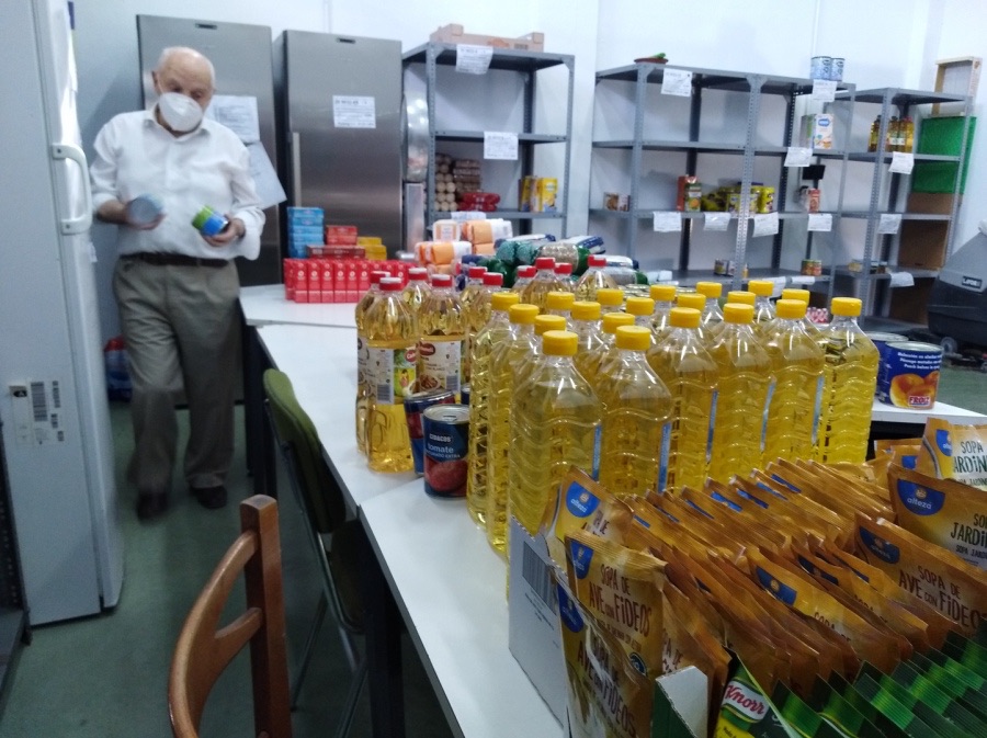 Voluntario con mascarilla en la sala de preparación de lotes, junto a botellas de aceite