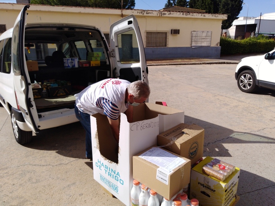 Voluntario preparando cajas de alimentos junto a una furgoneta