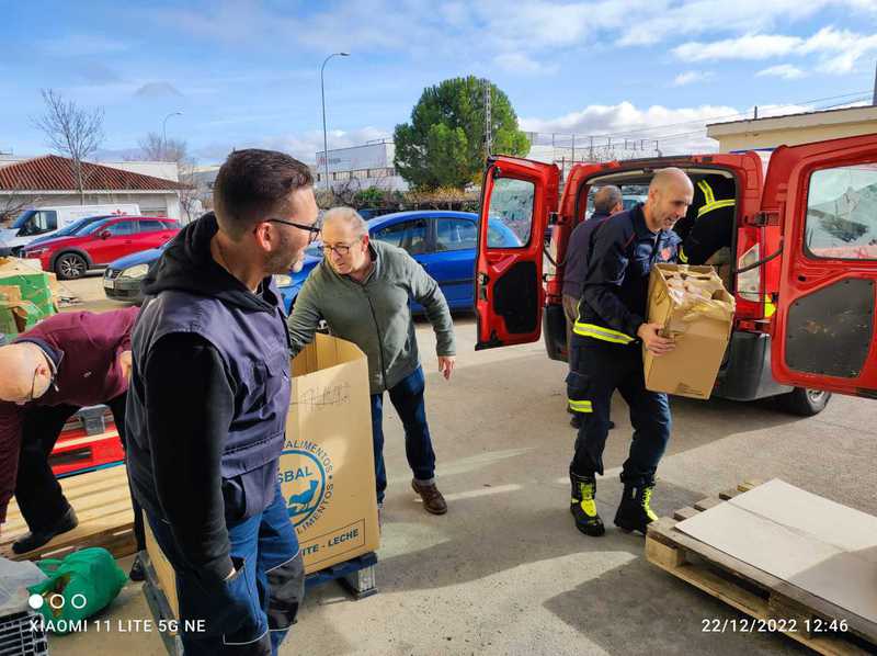 Bomberos de Toledo y voluntarios pasan las cajas de alimentos al almacén