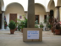 Caja de recogida de alimentos en un patio toledano con plantas y columnas