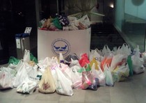 Bolsas de alimentos donados por el público del concierto junto a una caja del Banco de Alimentos