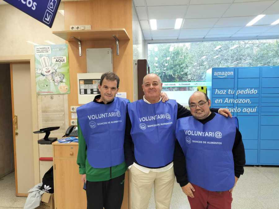 Tres voluntarios con petos en un centro comercial durante la Gran Recogida 2024