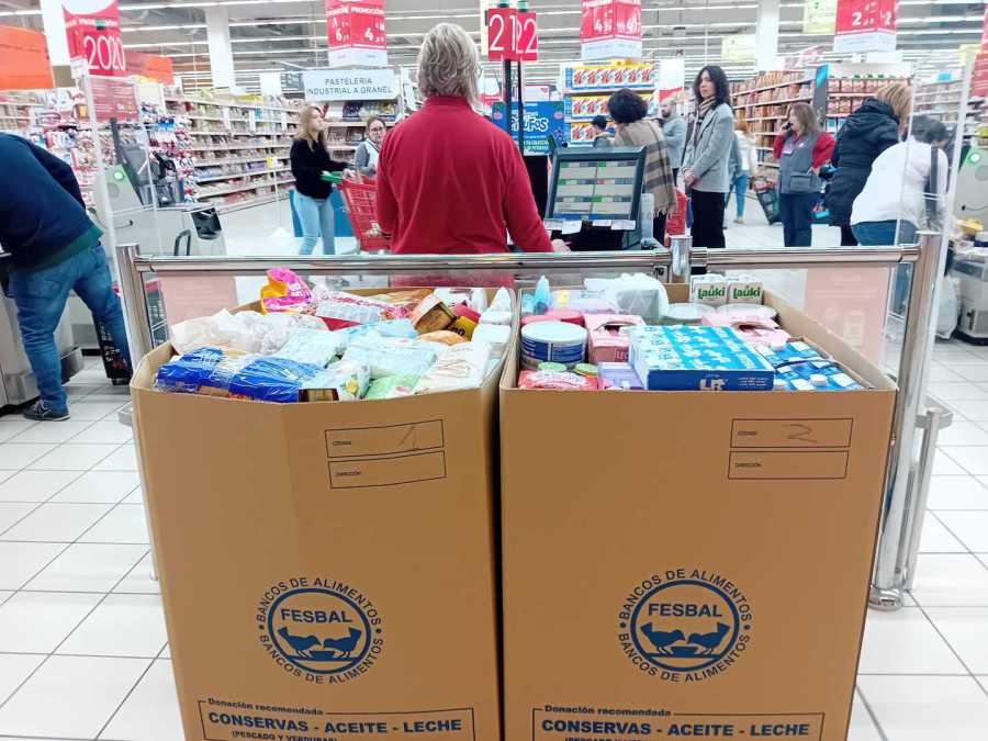 Cajas de FESBAL llenas de alimentos donados en la zona de cajas de un hipermercado