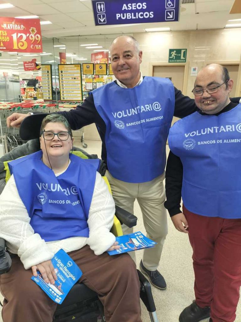 Voluntarios, una de ellas en silla de ruedas, con folletos de la Gran Recogida