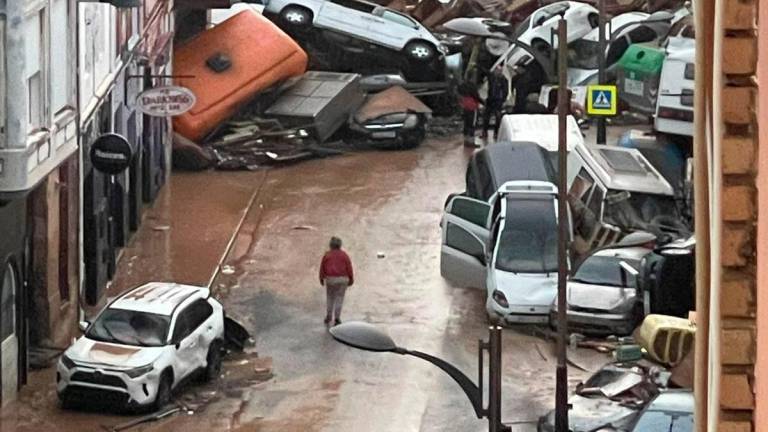 Calle inundada con coches amontonados tras la DANA