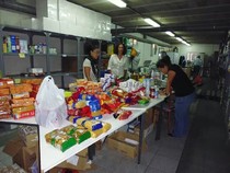 Voluntarios clasificando alimentos en mesas del almacén durante el recuento de la Gran Recogida