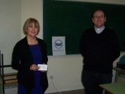 Dos personas junto a una caja de recogida del Banco de Alimentos en un colegio