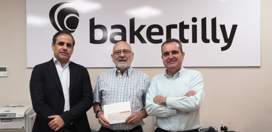 Representantes de Baker Tilly entregan su donación al presidente del Banco de Alimentos de Toledo
