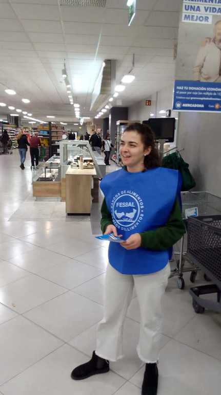 Voluntaria con peto de FESBAL en el pasillo de un supermercado