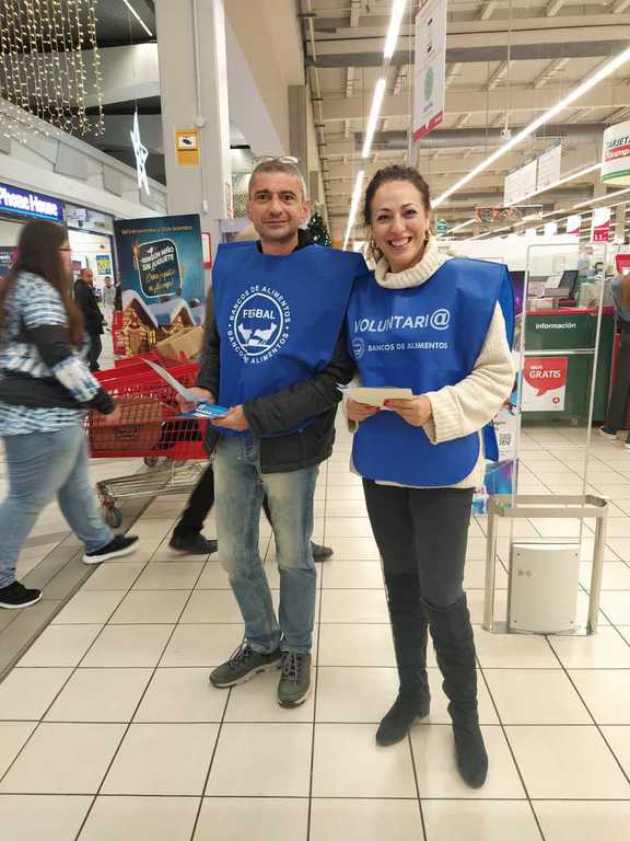Dos voluntarios con folletos en un hipermercado