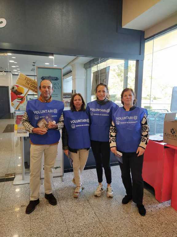 Grupo de voluntarios con petos a la entrada de una tienda