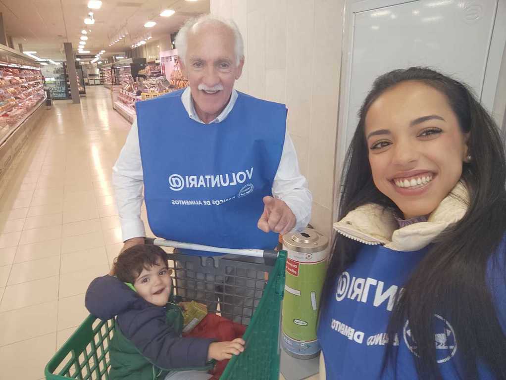 Selfi de una voluntaria con un voluntario veterano y un niño en un carro de la compra