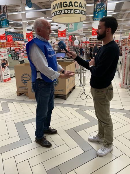 Un voluntario atiende a un periodista en un hipermercado durante la Gran Recogida
