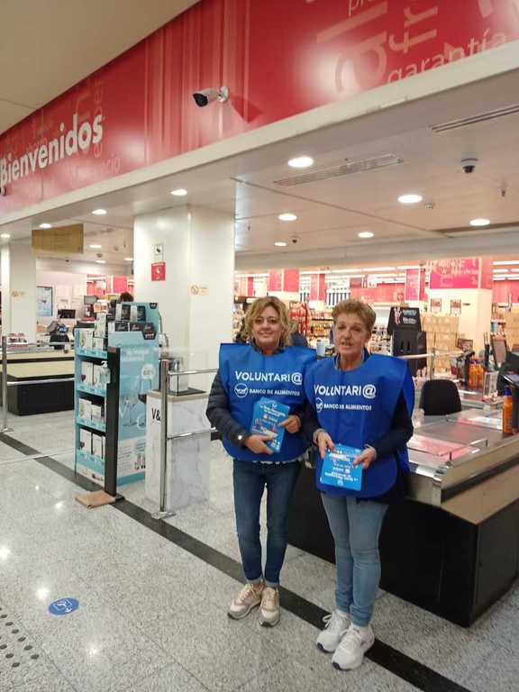 Dos voluntarias con petos a la entrada de un supermercado