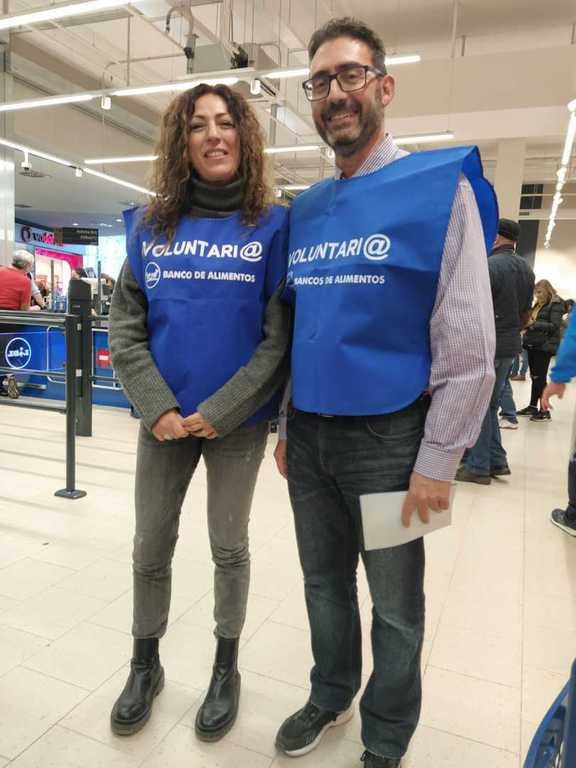 Voluntaria y voluntario con petos azules en un supermercado