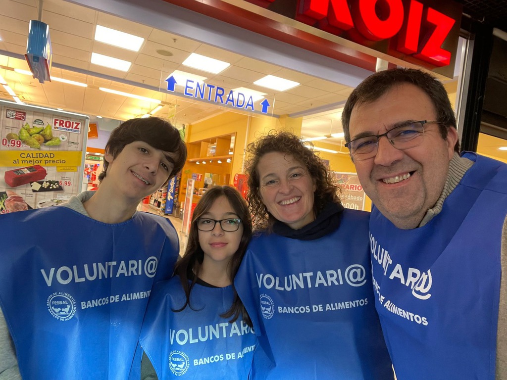Selfi de una familia de voluntarios a la entrada de un supermercado Froiz