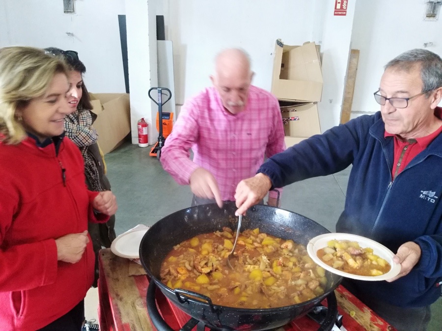 Voluntarios sirviendo la marmita casera en la comida de hermandad