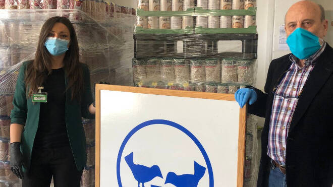 Representantes de Mercadona y del Banco de Alimentos con mascarilla junto a los alimentos donados