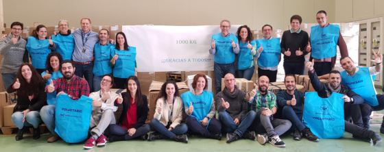 Voluntarios de la empresa Airbus con petos azules junto a los alimentos recogidos