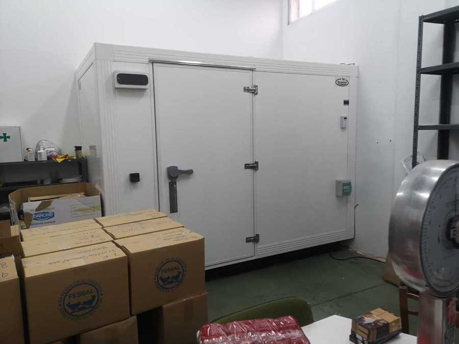 Cámara congeladora instalada dentro del almacén junto a cajas de alimentos