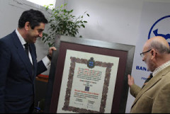 Visita institucional al Banco de Alimentos de Toledo: dos hombres observan un diploma enmarcado